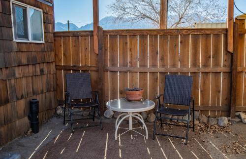 two chairs and a table in front of a fence at Mt Williamson Motel and Basecamp in Independence