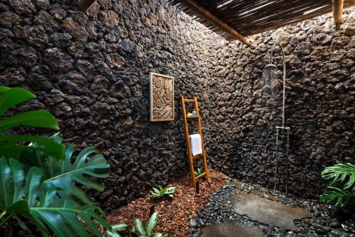 eine Steinmauer mit einer Dusche in einem Zimmer in der Unterkunft Four Seasons Resort Hualalai in Kaupulehu