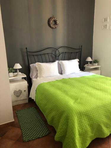 a bedroom with a green bed with two night stands at Tuscany Location in Marta