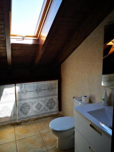 a bathroom with a toilet and a sink and a window at Finca Josefina in Miengo