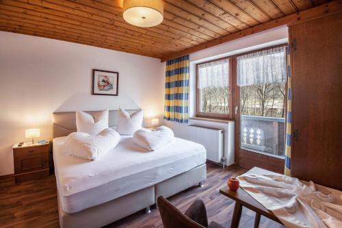 um quarto com uma cama com almofadas brancas e uma janela em Ferienwohnung Brugger 6 Personen em Kaltenbach