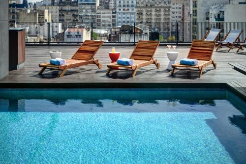 una piscina con 2 sillas junto a un edificio en Boutique Apartments - San Telmo en Buenos Aires