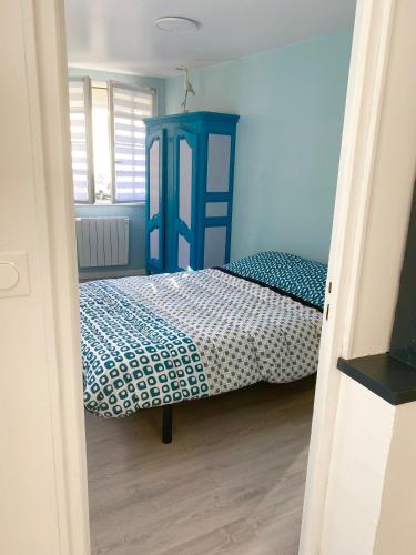 - une chambre avec un lit à tête bleue dans l'établissement L’Abri Côtier, au Tréport