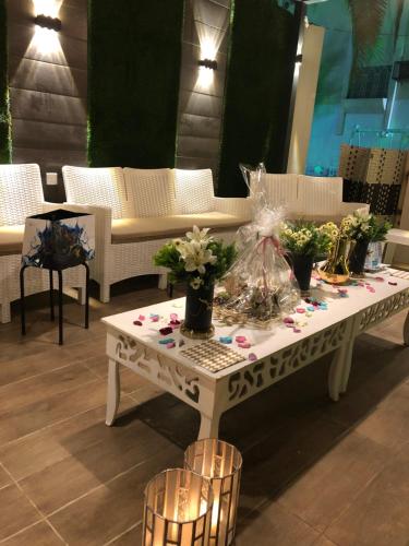 a white coffee table with flowers on top of it at شالية فاخر بمسبح خاص بمكة المكرمة in Makkah