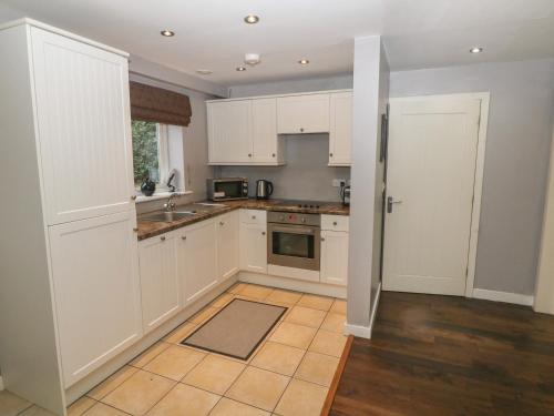 a kitchen with white cabinets and a tile floor at Bunbury in Alton