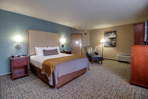 a hotel room with a bed and a chair at Best Western Harbour Pointe Lakefront in Saint Ignace