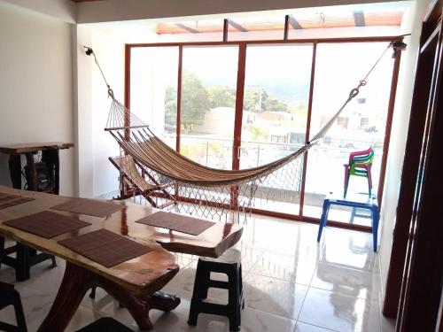 a hammock in a room with a large window at Lindo apartamento vacacional en guaduas in Guaduas