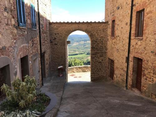 Une allée entre deux bâtiments avec une arche au milieu dans l'établissement Belvilla by OYO Vista dalla Terrazza, à Montecastelli