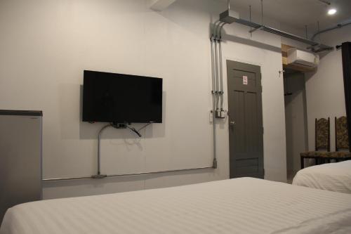 a room with two beds and a flat screen tv on the wall at The Good Days in Udon Thani