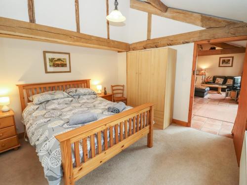 um quarto com uma grande cama de madeira num quarto em The Old Stables em Ross on Wye