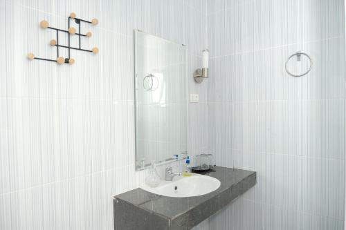 a bathroom with a sink and a mirror at Joyful Hotel in Tanjungpandan