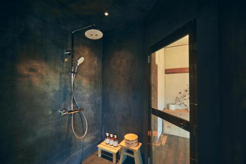 a blue bathroom with a shower and a sink at Kominkayado LOOF Kyonoie in Ōwatari