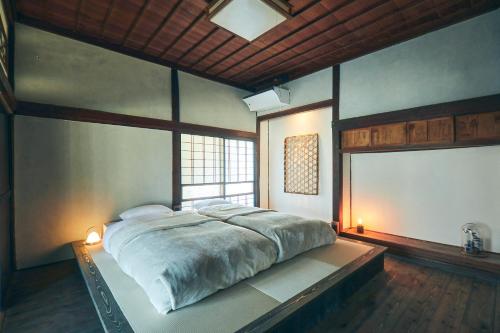una camera con un grande letto e una finestra di Kominkayado Loof Kyonoie 