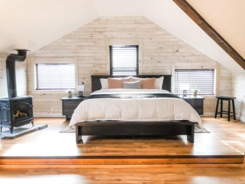 a bedroom with a large bed and a fireplace at Etherington Suites in Elora