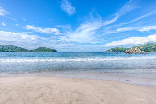 a sandy beach with a view of the ocean at La Villa Luz (sólo adultos) in Zihuatanejo