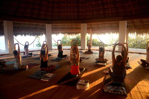 a group of people doing yoga in a pavilion at Zazil Retreat in San Agustinillo