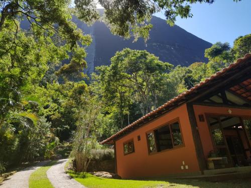 a house in a forest with a mountain in the background at Tékinfin, você chegou! Lindo sítio em Secretário! in Petrópolis