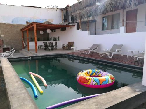 a swimming pool with two inflatables in a house at Hotel Navego in Lobitos