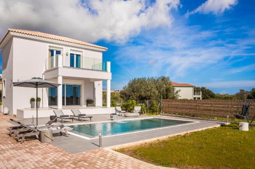 a villa with a swimming pool and a house at Artemon New Luxury Villa in Skala Kefalonias