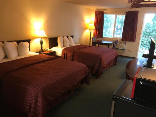 A bed or beds in a room at Smokey Point Motor Inn