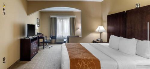 a hotel room with a large bed and a desk at Comfort Suites The Colony - Plano West in The Colony