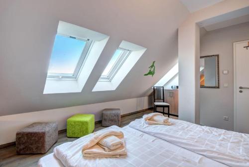 a bedroom with a bed and two skylights at Der Landhof Windflüchter in Stolpe auf Usedom