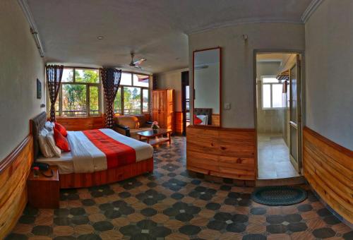 Highland Village Resort في دارامسالا: غرفة نوم مع سرير وغرفة معيشة