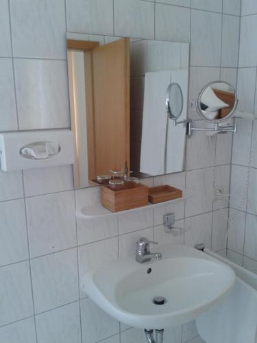 a white bathroom with a sink and a mirror at Forst´s Landhaus in Riedenburg