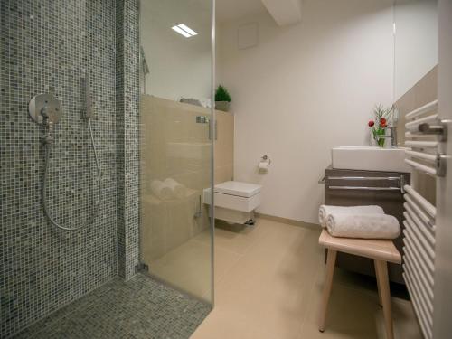 uma casa de banho com um chuveiro, um WC e um lavatório. em Dünenresidenz Prora - Skysuite mit freiem Meerblick, Dachterrasse und Balkon NP-502 em Binz