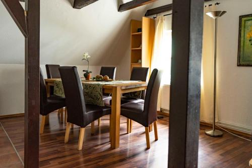 uma sala de jantar com uma mesa de madeira e cadeiras pretas em Ferienwohnung Alter Schneider em Hooksiel