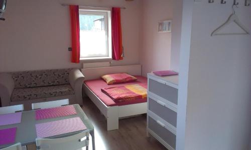 ein kleines Zimmer mit einem kleinen Bett und einem Fenster in der Unterkunft Studia Relax in Železná Ruda