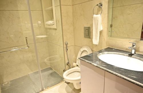 La salle de bains est pourvue d'une douche, d'un lavabo et de toilettes. dans l'établissement Hotel Aakriti Clarks Inn Express, à Bareilly