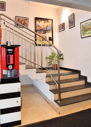 a staircase with a red machine in a room at Puthens Capitol Inn in Ernakulam