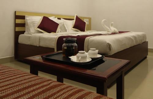 a hotel room with two beds and a table with a tray at Puthens Capitol Inn in Ernakulam
