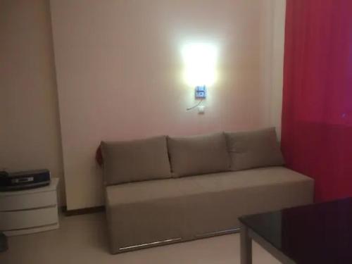 a living room with a couch and a light on the wall at Lux Apartment, Liko Grad in Kyiv