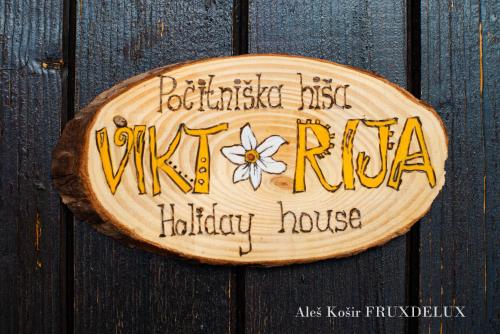 a wooden sign with graffiti on a wooden door at Pet & Family Friendly House Viktorija - house near Golica with Triglav view in Jesenice