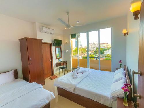 a bedroom with two beds and a large window at The Den 23 in Maradana