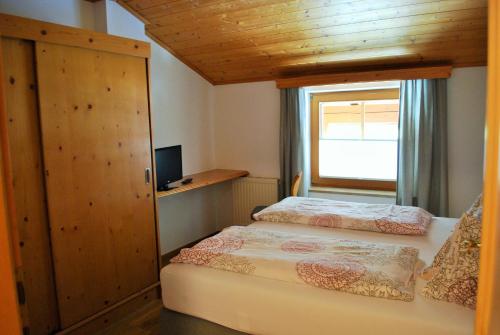 a small bedroom with two beds and a window at Filzmoos Appartements in Filzmoos