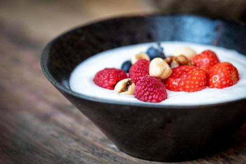 a bowl of yogurt with strawberries and blueberries and nuts at Broeck Oudewater in Oudewater