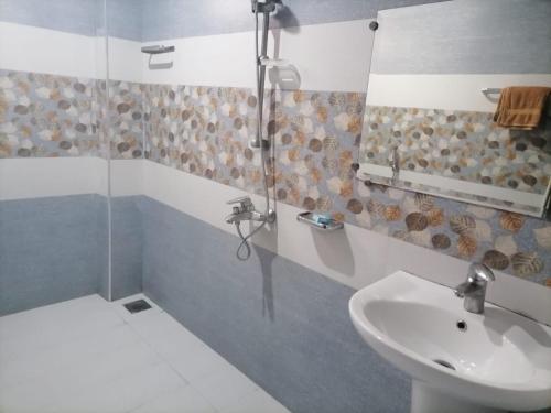 y baño con lavabo y ducha. en • Faizi Furnished Apartments, en Faisalabad