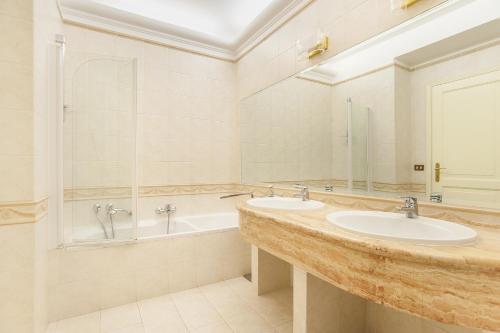 un bagno con 2 lavandini e una vasca di EUR Luminous and Large Family Terrace Apartment a Roma