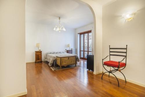 Habitación con cama y silla. en EUR Luminous and Large Family Terrace Apartment en Roma