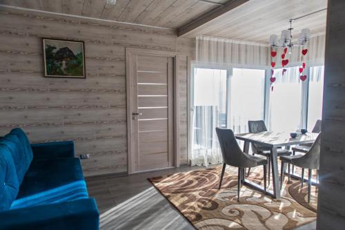 a living room with a blue couch and a table at Садиба Кичера та Кичера Еко in Mizhhirʼʼya