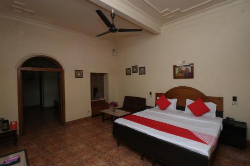 a bedroom with a large bed with red pillows at Central Hotel in Lucknow