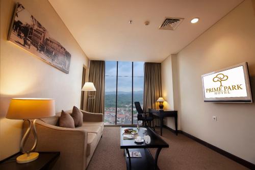 a living room with a couch and a large window at PRIME PARK Hotel Bandung in Bandung