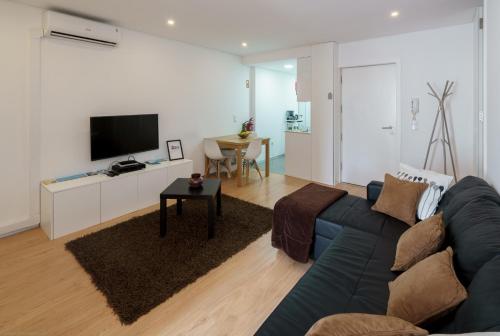 a living room with a blue couch and a tv at I Love Vila do Conde in Vila do Conde