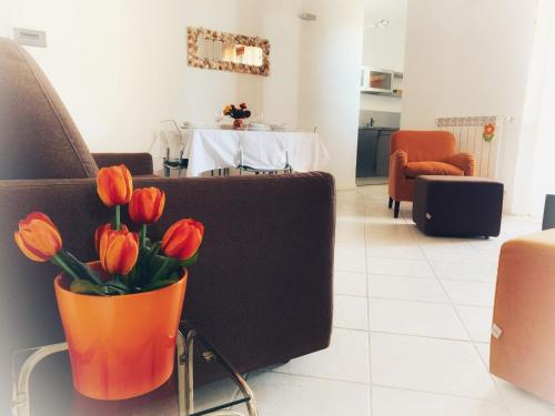 an orange vase with red tulips in a living room at Residenza l'Ulivo in Alberese