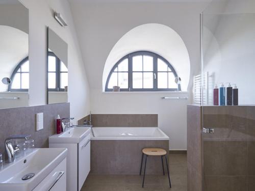Baño blanco con bañera y lavamanos en Reetland am Meer - Premium Reetdachvilla mit 3 Schlafzimmern, Sauna und Kamin E16 en Dranske