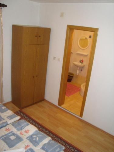 a bedroom with a mirror and a cabinet and a sink at Pansion Ljubica in Međugorje