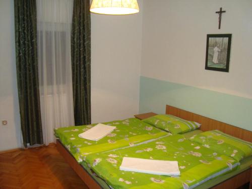 a bedroom with a bed with a green blanket at Pansion Ljubica in Međugorje